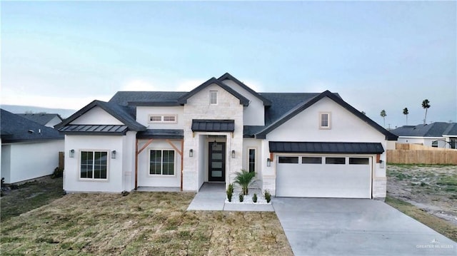 view of front of property with concrete driveway, a standing seam roof, metal roof, a garage, and stone siding