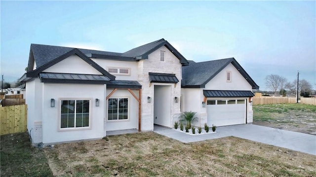 modern inspired farmhouse with a standing seam roof, fence, metal roof, stone siding, and driveway