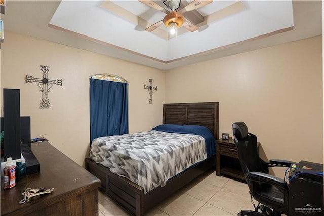 bedroom with a raised ceiling, ceiling fan, and light tile patterned floors