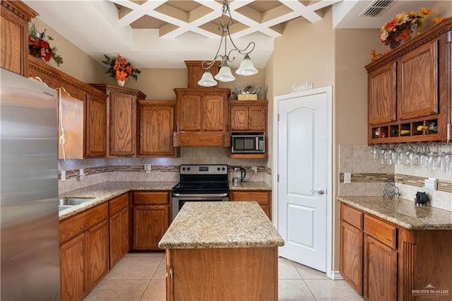 kitchen featuring a center island, stainless steel appliances, coffered ceiling, light stone counters, and backsplash