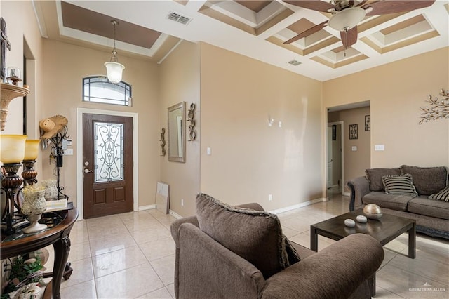 interior space featuring coffered ceiling, ceiling fan, light tile patterned floors, and a tray ceiling