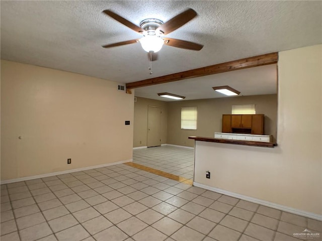 empty room with beamed ceiling, a textured ceiling, and visible vents