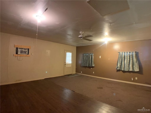 basement featuring ceiling fan, wood finished floors, baseboards, and a wall mounted AC