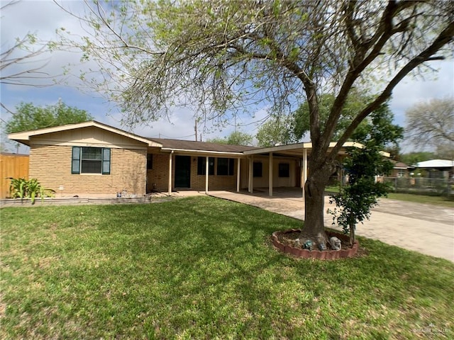 exterior space featuring brick siding, driveway, a front lawn, and a carport