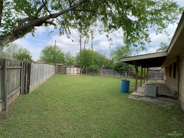 view of yard featuring an outbuilding, central air condition unit, a storage unit, and a fenced backyard