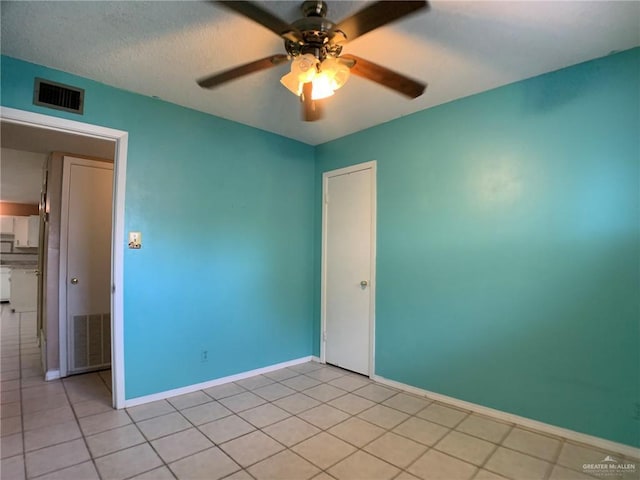 empty room featuring visible vents, a textured ceiling, baseboards, and a ceiling fan