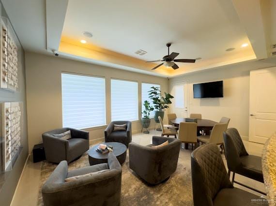 interior space featuring a raised ceiling and ceiling fan