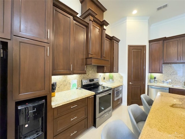 kitchen featuring decorative backsplash, appliances with stainless steel finishes, and light stone countertops