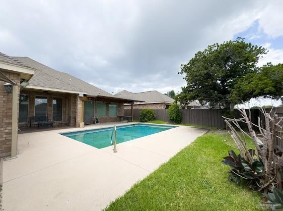 view of swimming pool featuring a yard and a patio area