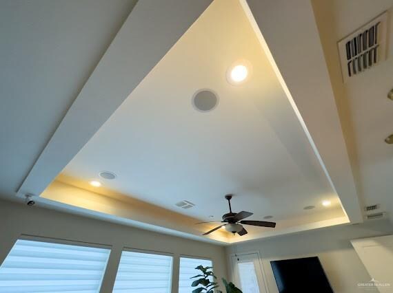 room details featuring ceiling fan and a raised ceiling