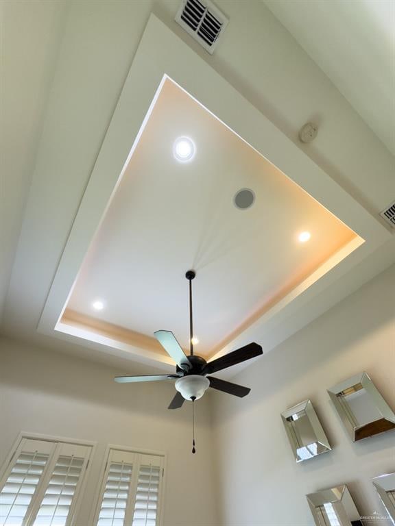 interior details featuring a raised ceiling and ceiling fan