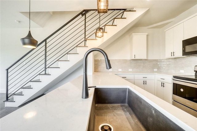 kitchen with white cabinetry, stainless steel electric range oven, sink, tasteful backsplash, and pendant lighting