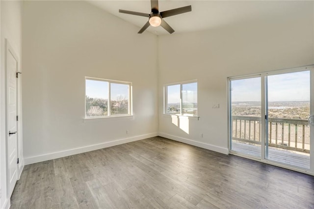 empty room featuring ceiling fan, dark hardwood / wood-style floors, and high vaulted ceiling