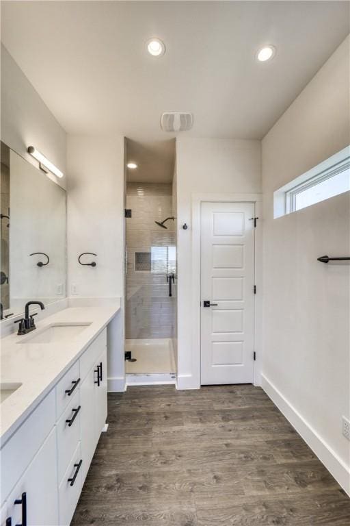 bathroom featuring an enclosed shower, hardwood / wood-style floors, and double vanity