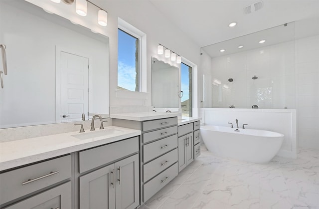 bathroom with double vanity, a washtub, and tile floors