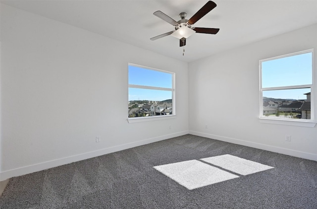 carpeted spare room with ceiling fan