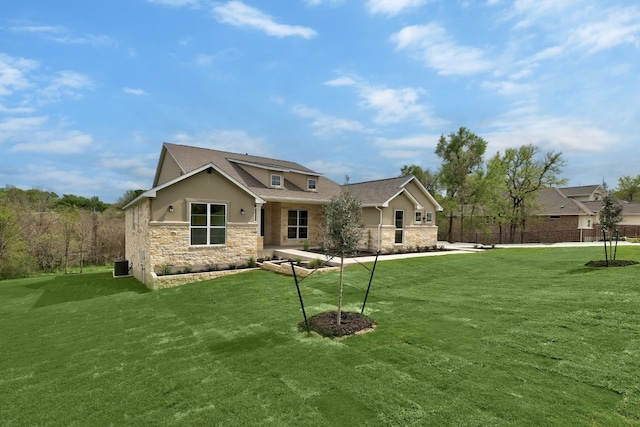 view of front of property featuring a front yard and central AC