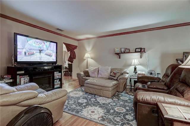 living room featuring crown molding and light hardwood / wood-style flooring