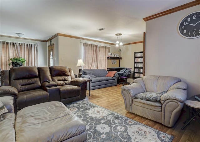 living room featuring crown molding, a chandelier, and hardwood / wood-style flooring