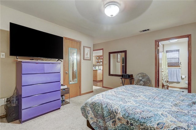 bedroom featuring light carpet, ceiling fan, and ensuite bathroom