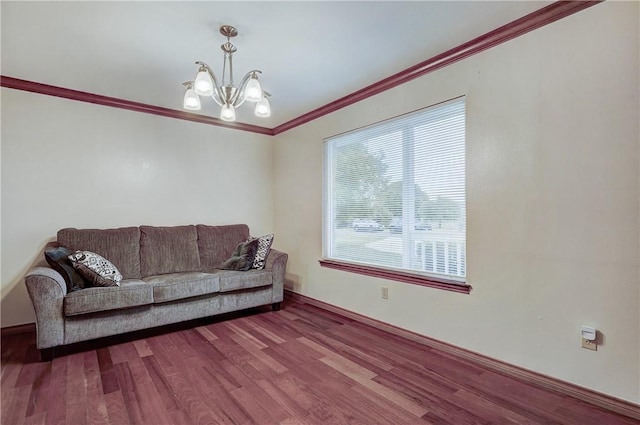 living room featuring an inviting chandelier, dark hardwood / wood-style floors, and ornamental molding