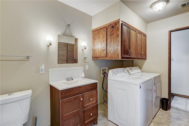 clothes washing area with light tile floors, sink, washer hookup, and washing machine and clothes dryer