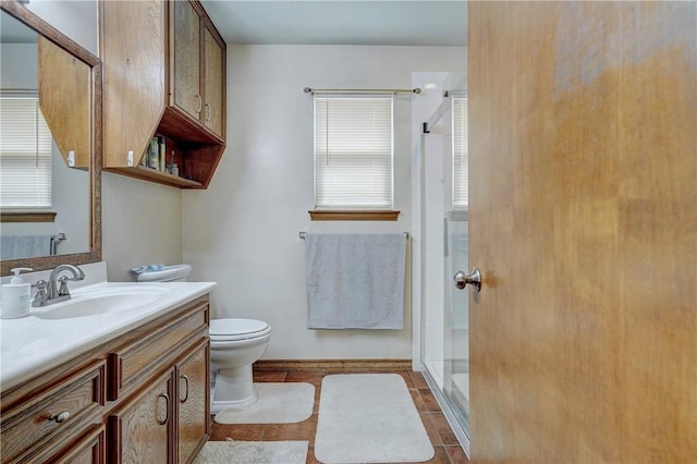 bathroom featuring toilet, large vanity, plenty of natural light, and tile flooring