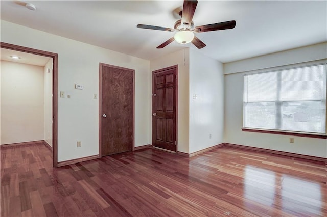 unfurnished room featuring ceiling fan and dark wood-type flooring