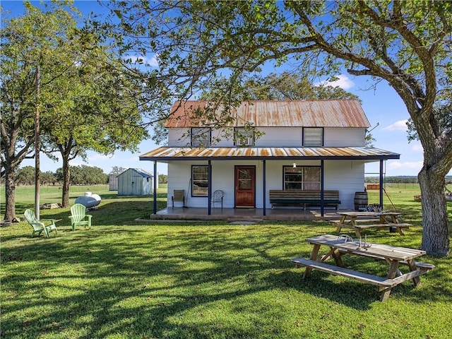 back of house with a yard, a storage shed, and a porch