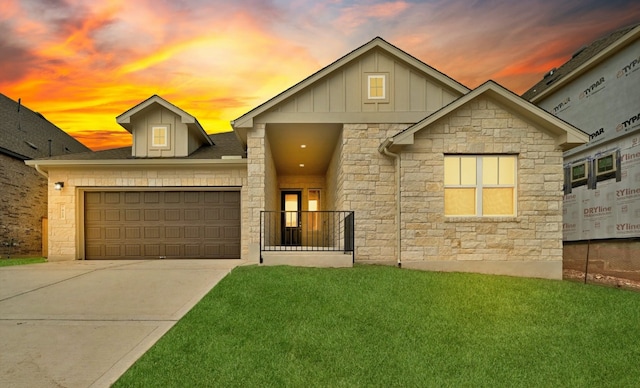 view of front of property featuring a garage and a lawn