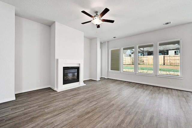 unfurnished living room featuring ceiling fan and hardwood / wood-style flooring