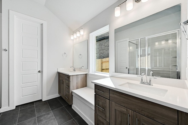 bathroom featuring dual vanity, vaulted ceiling, and tile patterned flooring