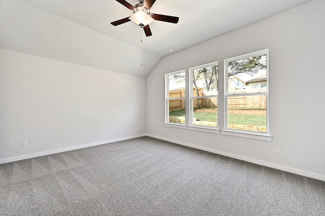 carpeted empty room featuring ceiling fan and vaulted ceiling