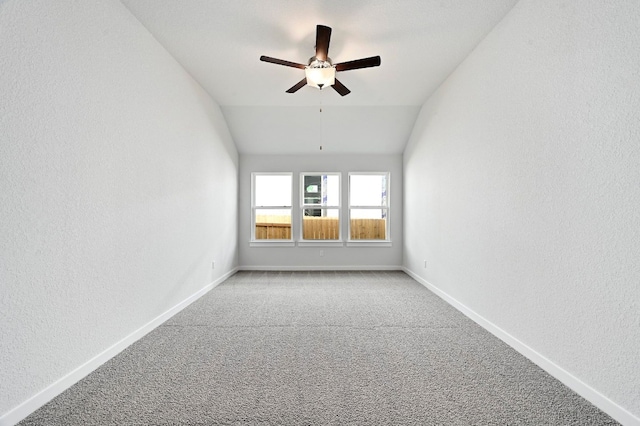 carpeted empty room featuring ceiling fan and vaulted ceiling