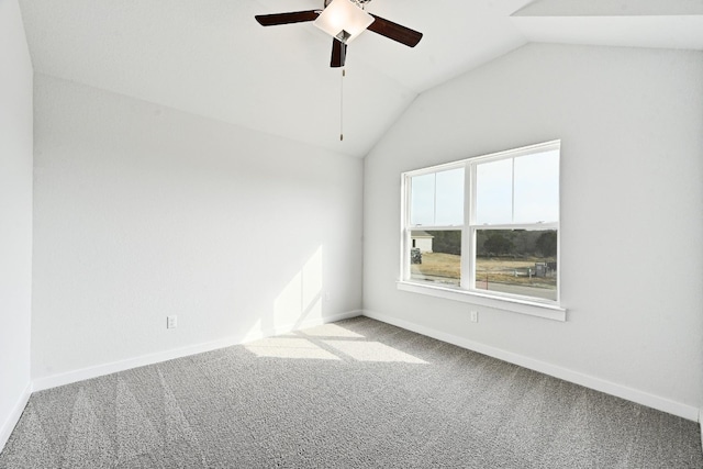 spare room with ceiling fan, vaulted ceiling, and light colored carpet