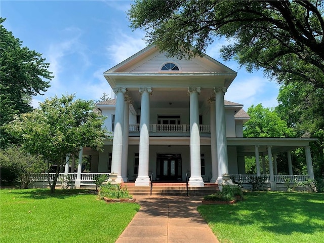 view of front of property with a front lawn, a balcony, and a porch