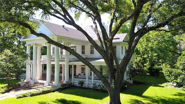 view of front of property featuring a balcony, a porch, and a front yard