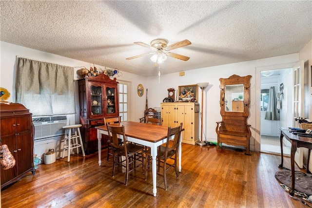 dining space with ceiling fan, a textured ceiling, and dark hardwood / wood-style flooring