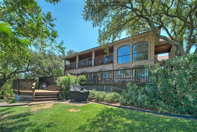 back of house featuring a lawn and a deck