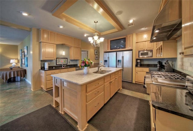 kitchen featuring appliances with stainless steel finishes, hanging light fixtures, an island with sink, custom exhaust hood, and a chandelier