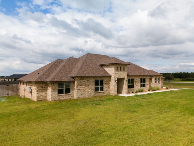 rear view of house featuring a lawn