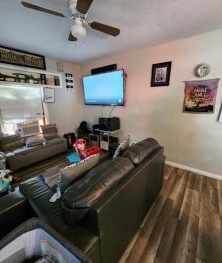 living room featuring dark hardwood / wood-style flooring and ceiling fan