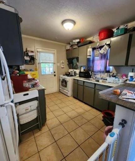 kitchen with light tile flooring, crown molding, and white range