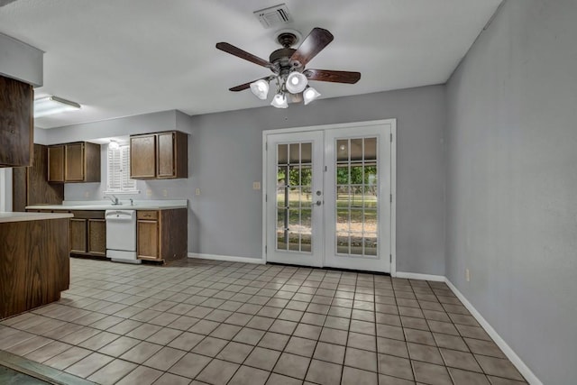 kitchen featuring ceiling fan, light tile floors, dishwasher, a healthy amount of sunlight, and french doors