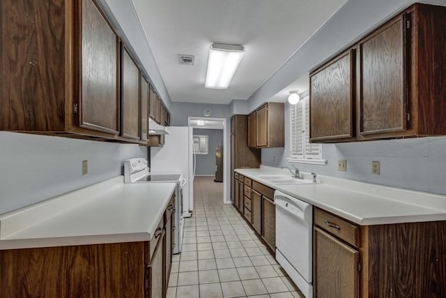 kitchen with light tile flooring, white appliances, exhaust hood, sink, and dark brown cabinetry