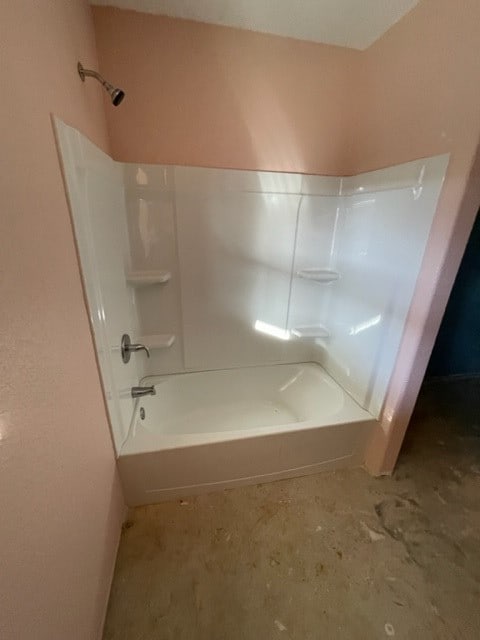 bathroom with shower / washtub combination and concrete flooring