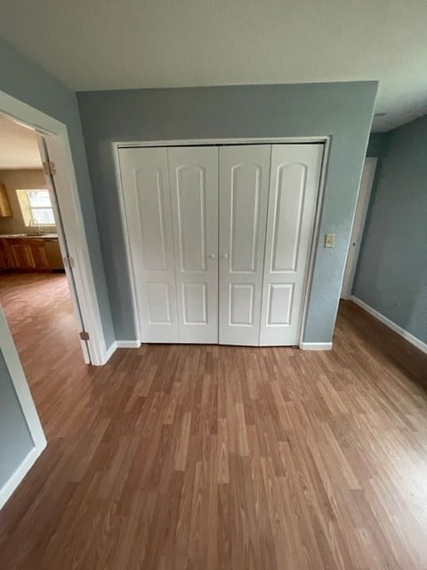 unfurnished bedroom with a closet and light wood-type flooring