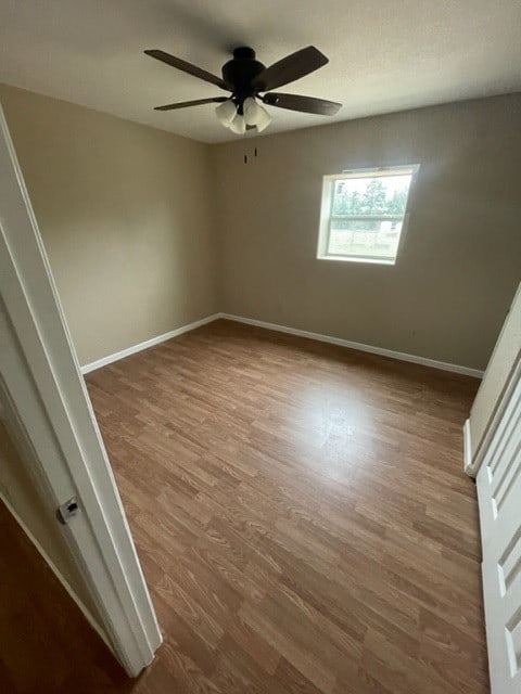 empty room featuring dark hardwood / wood-style floors and ceiling fan