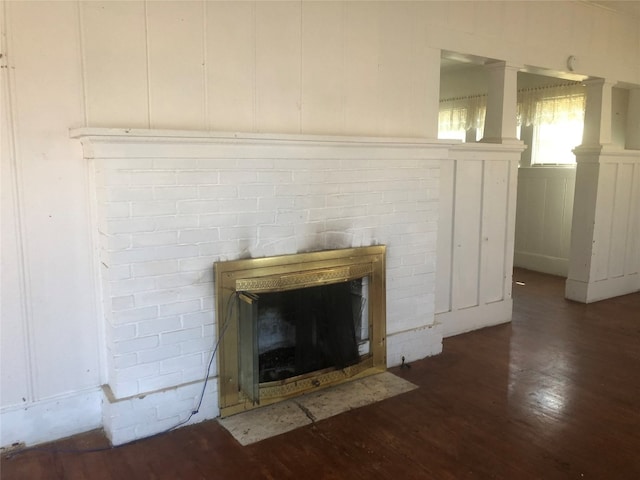 room details featuring a brick fireplace and dark wood-type flooring