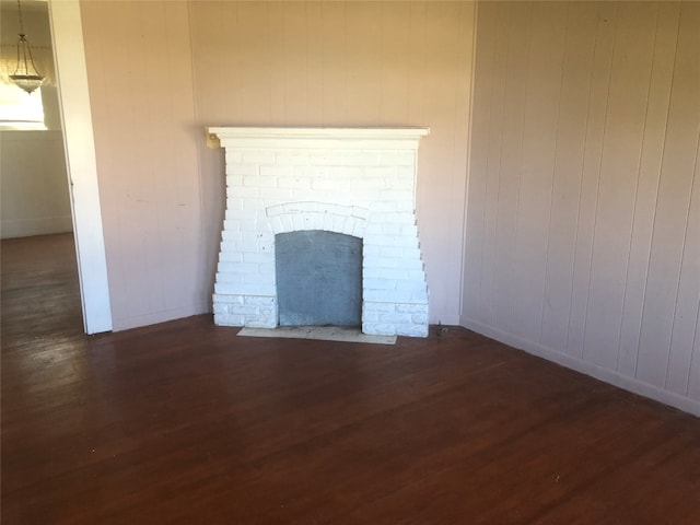 interior space with a brick fireplace and dark hardwood / wood-style flooring